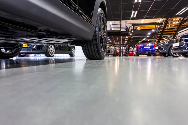 Strakke, glanzende naadloze vloer in een moderne bedrijfsomgeving met industriële uitstraling. De vloer reflecteert licht en geeft een schoon, georganiseerd karakter.