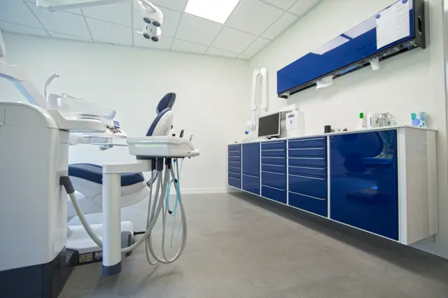 Schone, lichte bedrijfsruimte met naadloze vloer in neutraal grijs. Strakke witte wanden, professionele blauwe accenten en optimale belichting creëren een rust- en hygienische uitstraling.