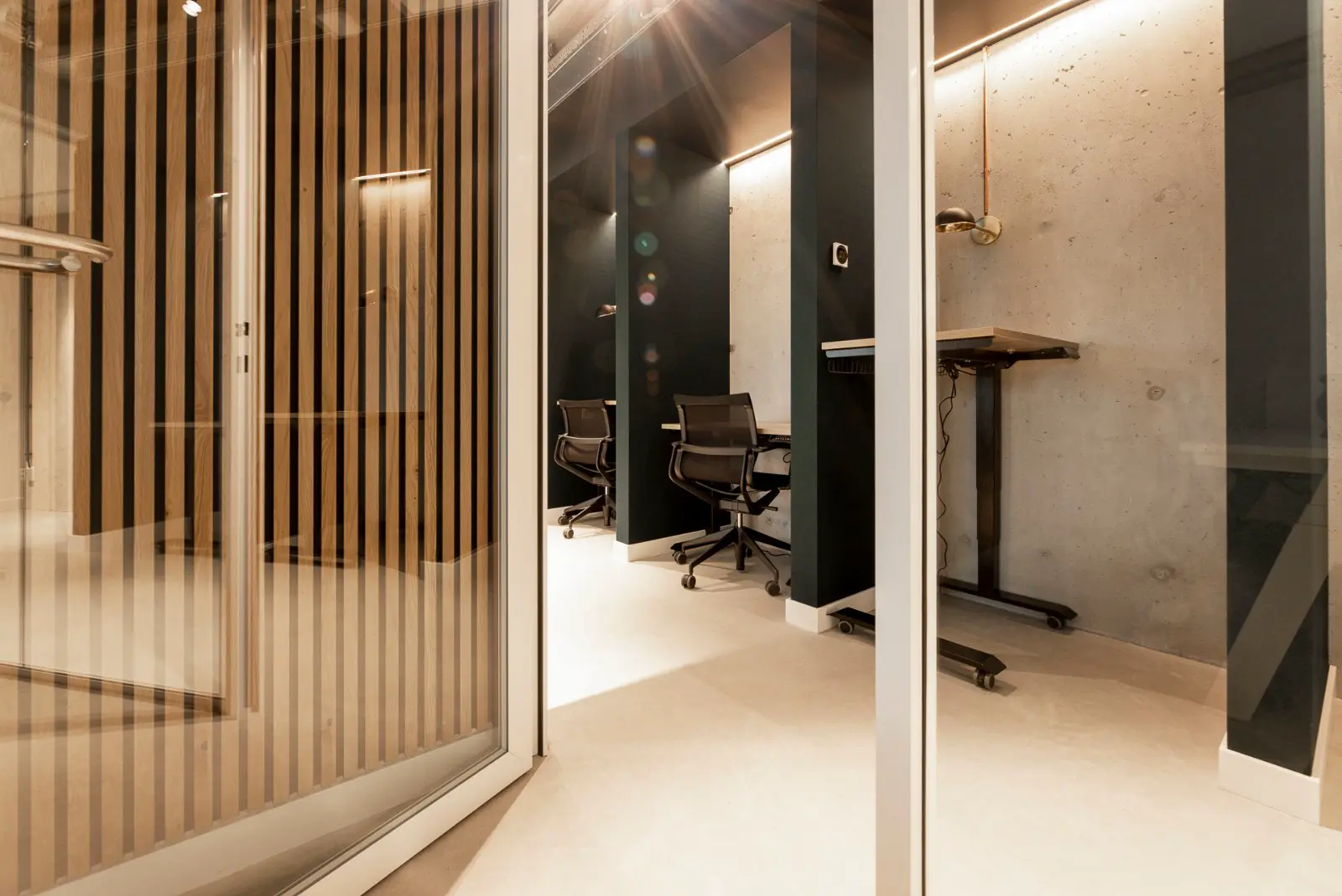 Schoon, strak kantoorinterieur met lichte naadloze vloer, houten latten-scheidingswand en minimalistisch design. Perfecte afwerking met scherpe lijnen en professionele uitstraling.