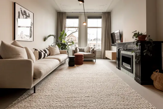 Serene woonkamer met een strakke, lichte naadloze vloer die visueel de ruimte vergrroot. De vloer vormt een rustige basis onder elegant ingericht interieur met neutrale tinten, natuurlijk licht en minimalistische styling.