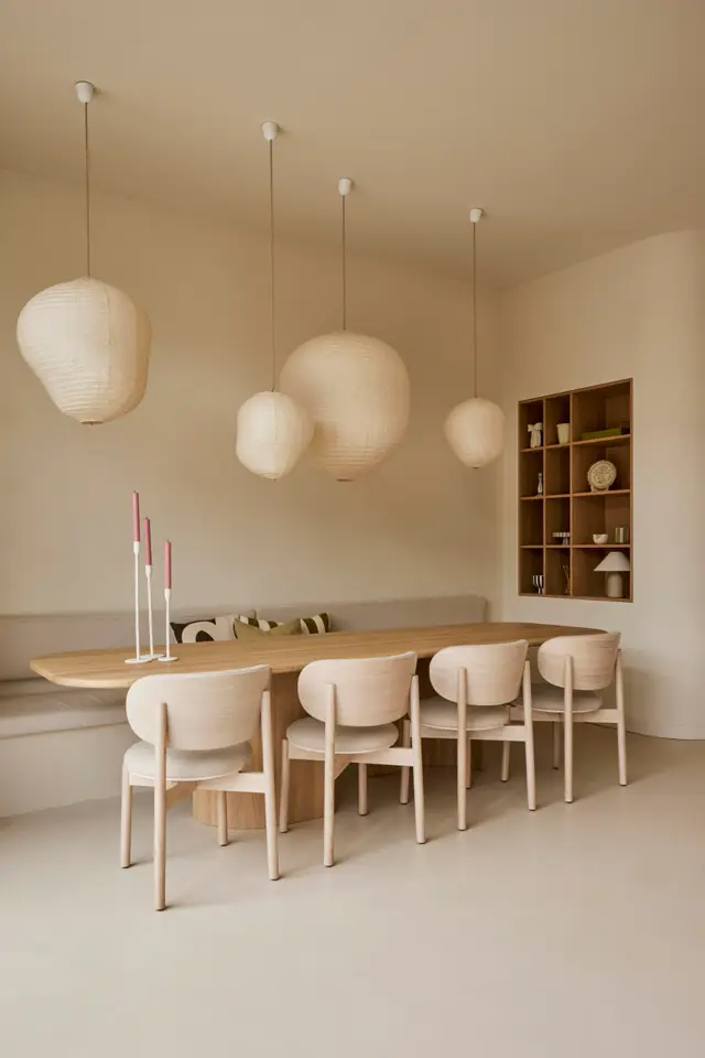 Een serene eetkamer met natuurlijke houttinten, waarin een schone naadloze vloer en wanden de perfecte backdrop vormen voor scandinavisch design met hangende lampjes en opgeruimd meubilair.