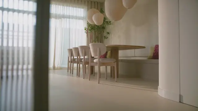 Een serene eetkamer met een strakke naadloze vloer in warm beige, natuurlijk licht van grote ramen, en elegant houten meubilair. De ruimte ademt rust uit met subtiele groene accenten en verfijnde details.